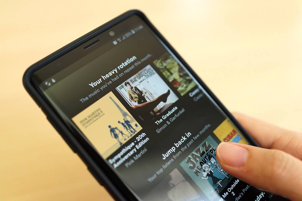 Smartphone displaying music streaming app interface with playlists and album covers