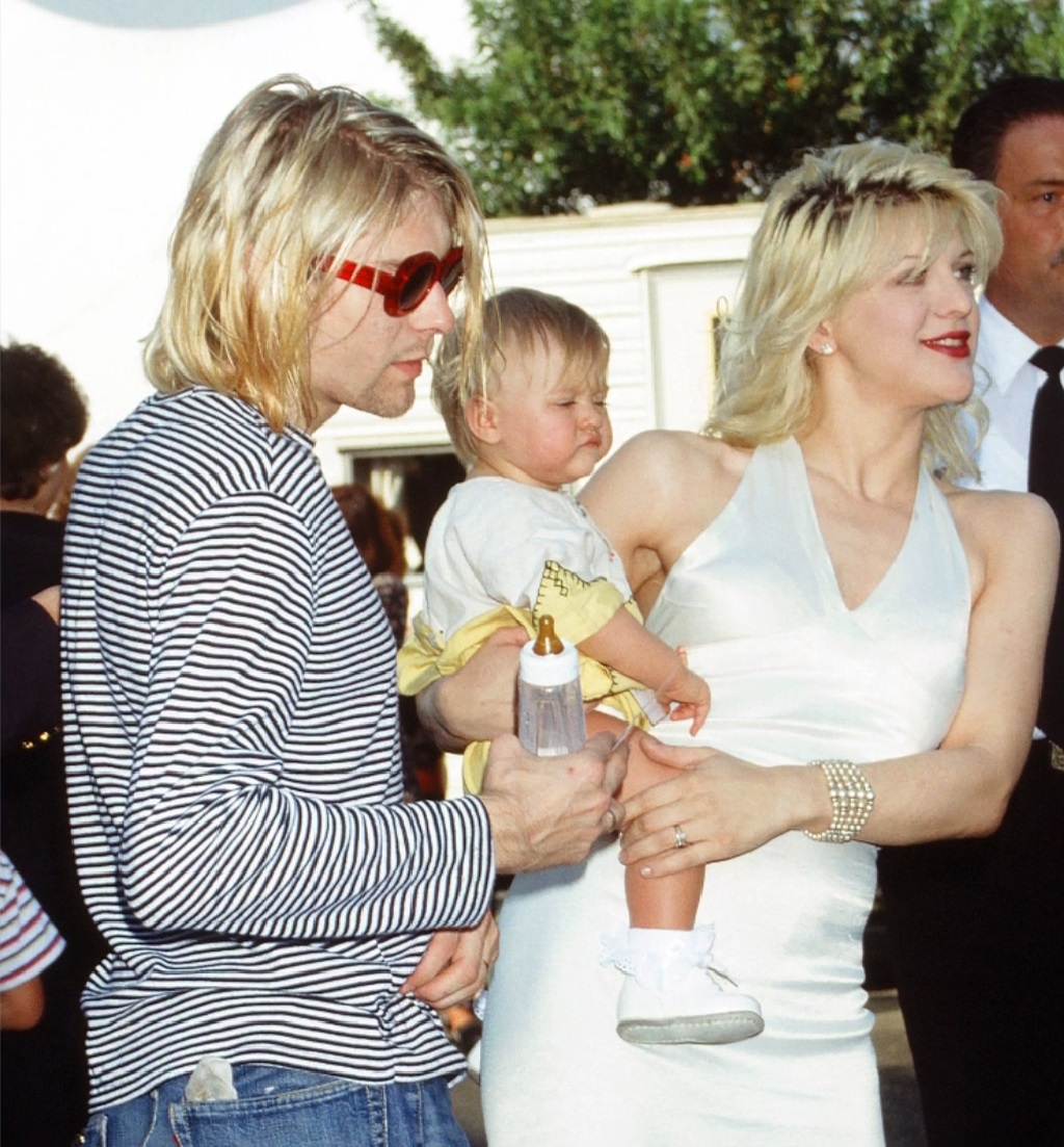 Frances Bean Cobain as a baby with her parents at a public event, held by Courtney Love, with Kurt Cobain beside them