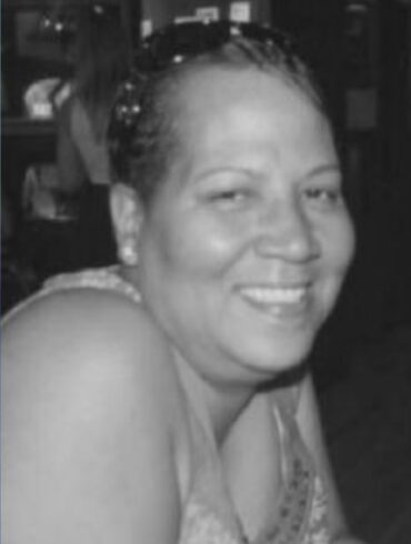 Black-and-white photo of a woman smiling warmly at the camera