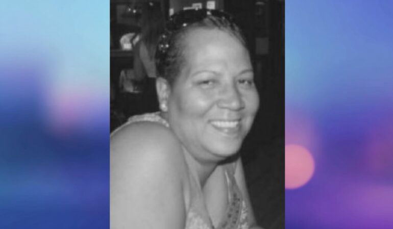 Black-and-white photo of a woman smiling warmly at the camera
