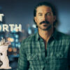 Riley Green standing in front of city lights with “Net Worth” text and a money bag graphic