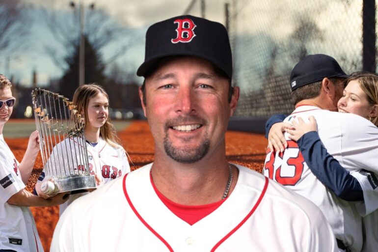 Baseball player in a Red Sox uniform smiling, with family and a championship trophy in the background