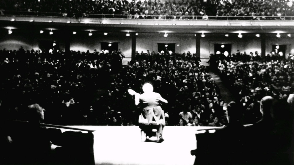 Black-and-white photo of Andrés Segovia performing on stage before a large audience