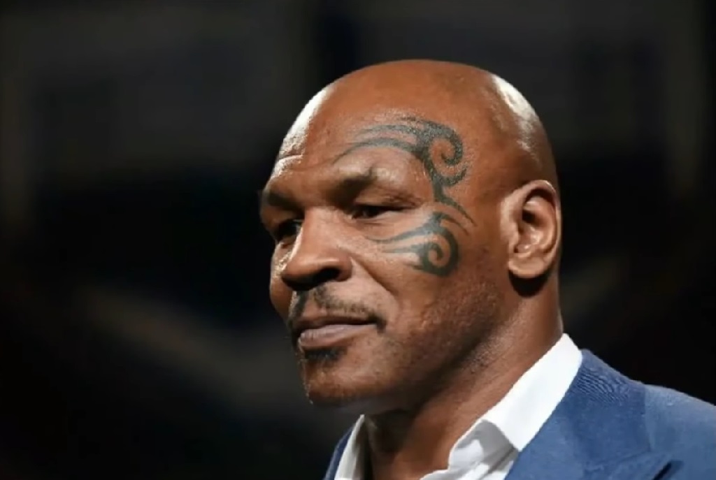 Close-up of Mike Tyson wearing a suit, with his signature tribal tattoo on his face