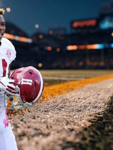 Henry Ruggs in an Alabama football uniform holding his helmet on the sideline of a stadium