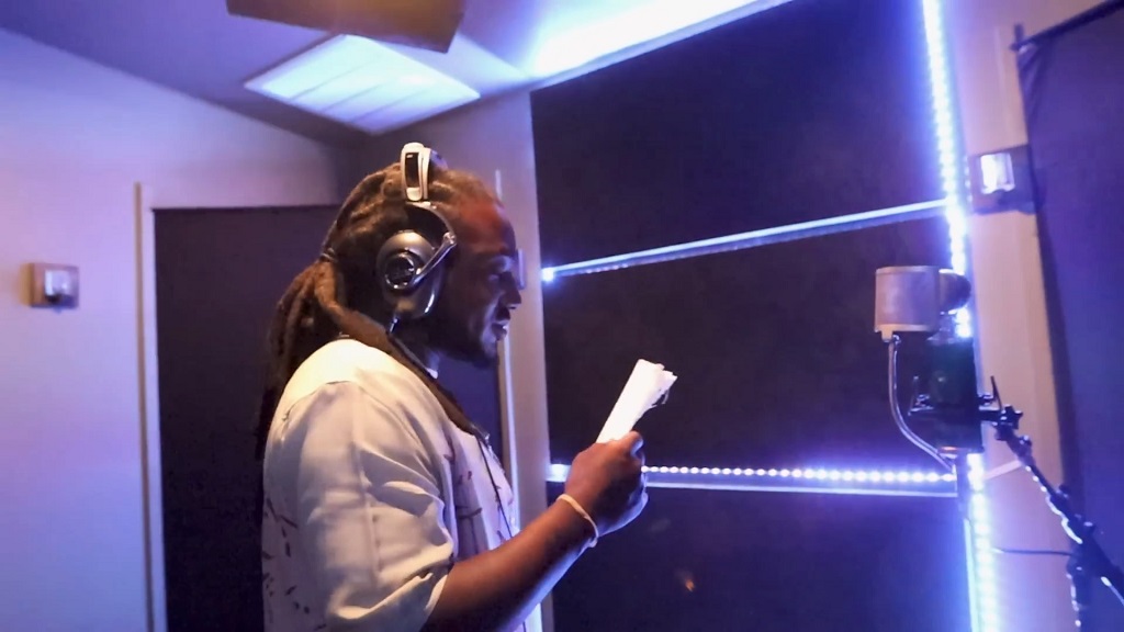 Hip hop artist Mozzy recording vocals in a studio