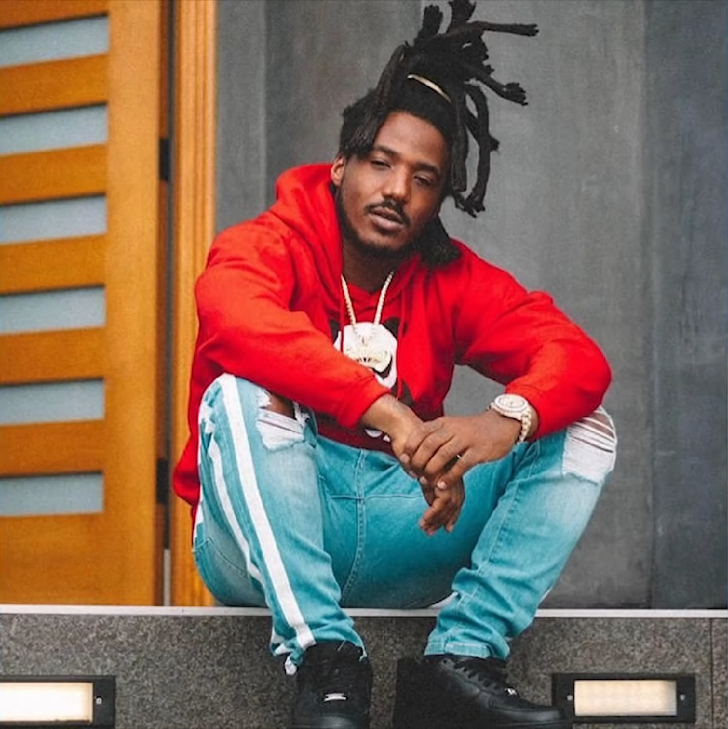 Hip hop artist Mozzy sitting on outdoor steps in casual clothing