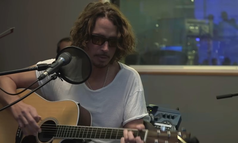 Chris Cornell playing a guitar in a studio, wearing sunglasses