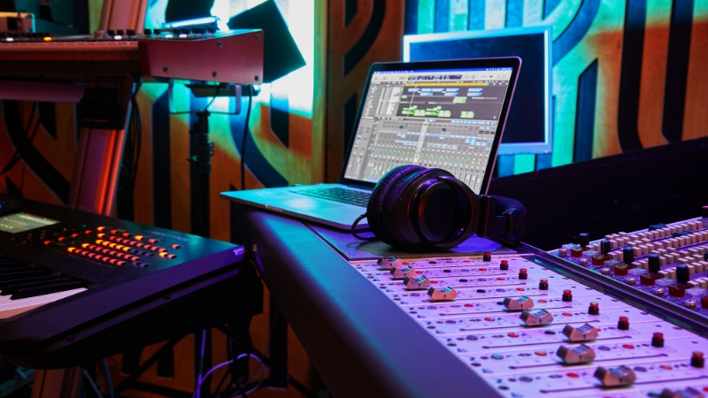 Home studio desk with laptop, audio interface, and controllers used to build a free rock plugin chain