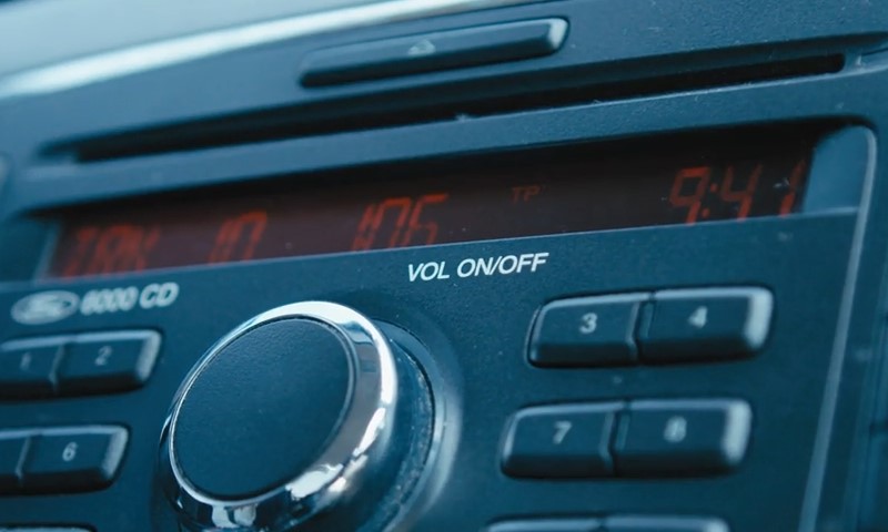 Close-up of a car radio panel with a digital display showing "9:41" and "106 FM."