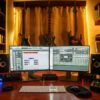 Home music studio setup with dual monitors, guitars, and mixing gear used with free VST plugins for rock production