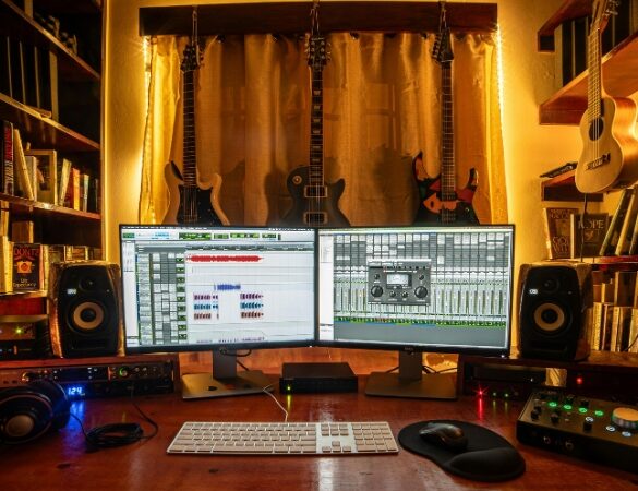 Best Free VST Plugins for Rock Producers - EQ, Compression, Amp Sims, Reverbs Home music studio setup with dual monitors, guitars, and mixing gear used with free VST plugins for rock production