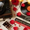 Turntable spinning vinyl records on a romantic table with red rose petals scattered around