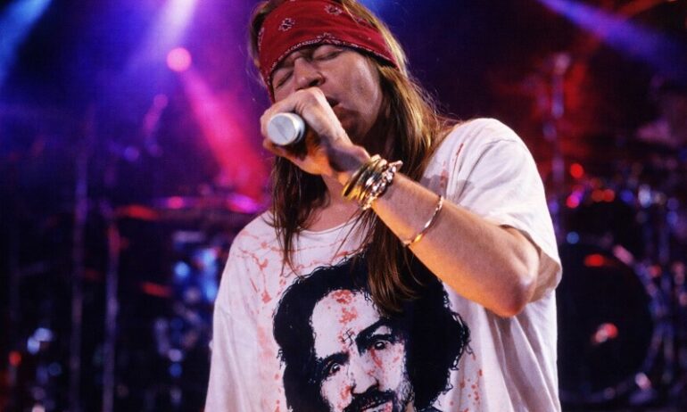 The Bandana in Rock Culture: 10 Iconic Moments That Defined a Generation Axl Rose singing on the stage during a concert, wearing white shirt and red bandana