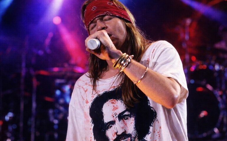 The Bandana in Rock Culture: 10 Iconic Moments That Defined a Generation Axl Rose singing on the stage during a concert, wearing white shirt and red bandana
