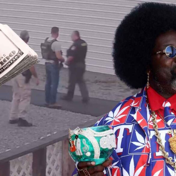 Afroman holding a decorated cup with police scene and money imagery in the background