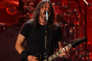 Dave Grohl passionately performs on stage, singing into a mic