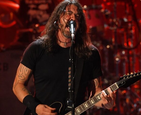 Dave Grohl passionately performs on stage, singing into a mic