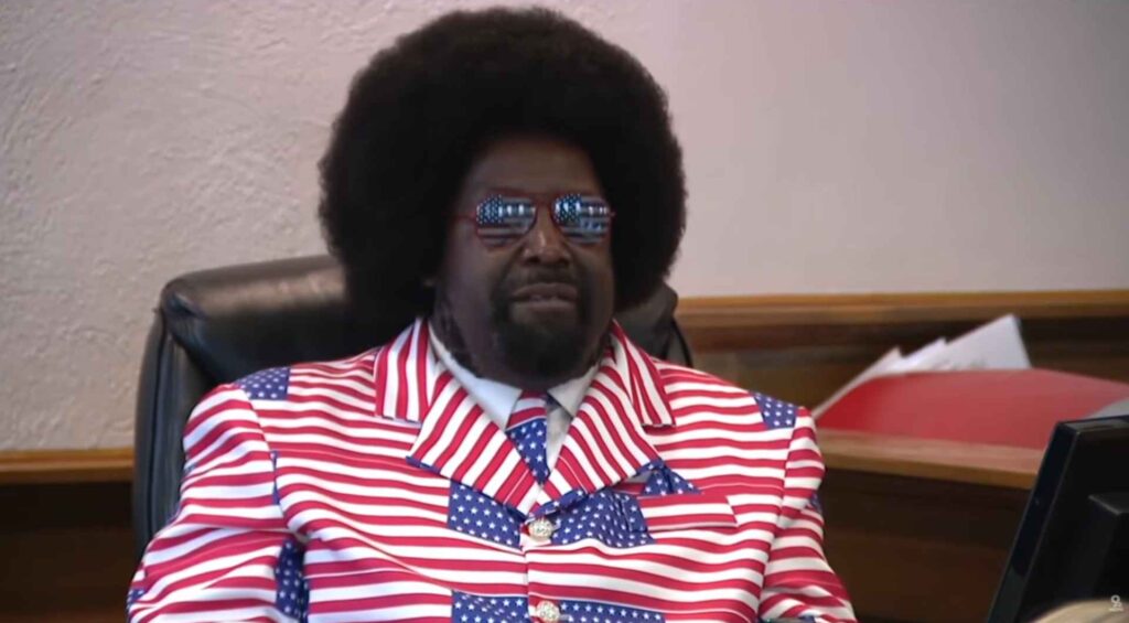 Afroman Wins Lawsuit Against Police After Viral Raid Music Videos Afroman wearing a red white and blue suit sitting in a courtroom