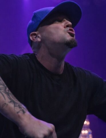 Limp Bizkit Comeback Story: What Changed After Sam Rivers Death Fred Durst in a black shirt and blue cap performing energetically on stage
