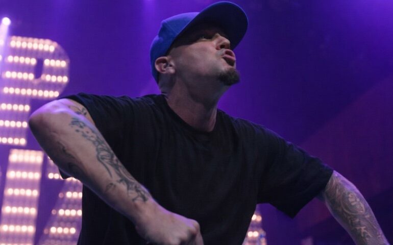 Limp Bizkit Comeback Story: What Changed After Sam Rivers Death Fred Durst in a black shirt and blue cap performing energetically on stage