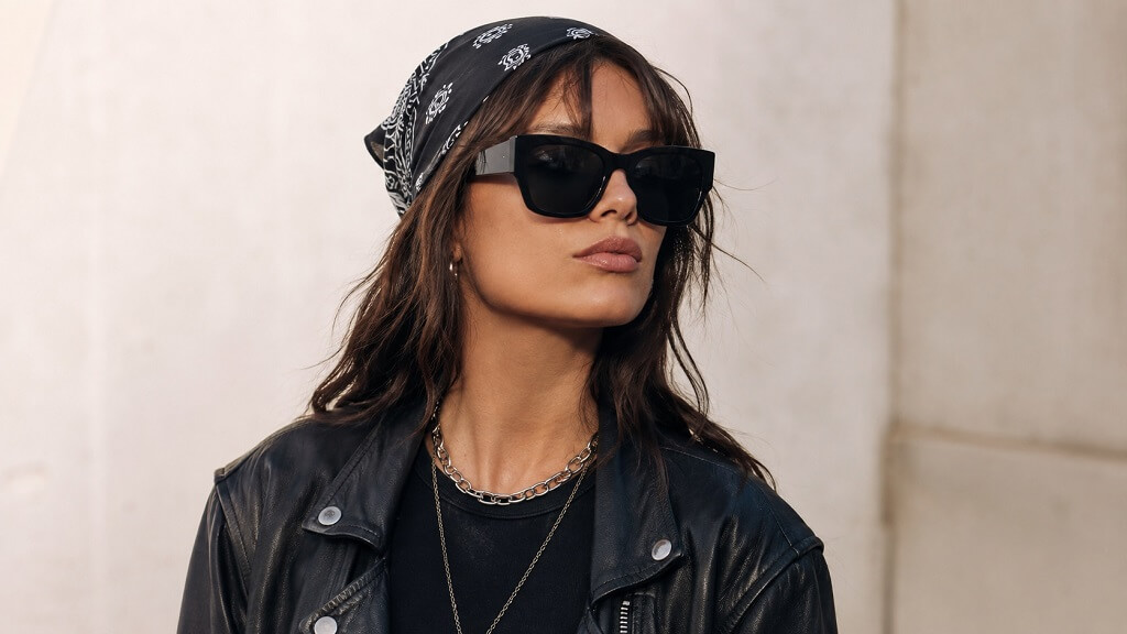 7 Bold Accessories That Give Any Outfit a Rock Edge Adult woman wearing a black bandana, oversized sunglasses, and a leather jacket