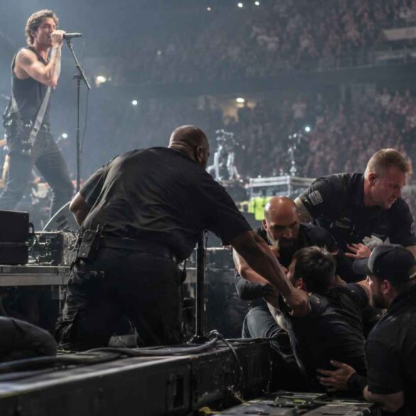 7 Crazy Behind-the-Scenes Moments That Happened During Live Concerts Behind-the-Scenes -Security guards removing an intruder from the stage during a crowded rock concert.