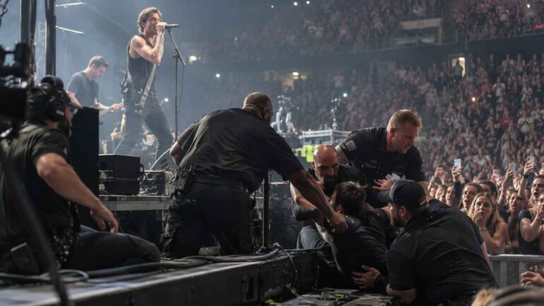 7 Crazy Behind-the-Scenes Moments That Happened During Live Concerts Behind-the-Scenes -Security guards removing an intruder from the stage during a crowded rock concert.