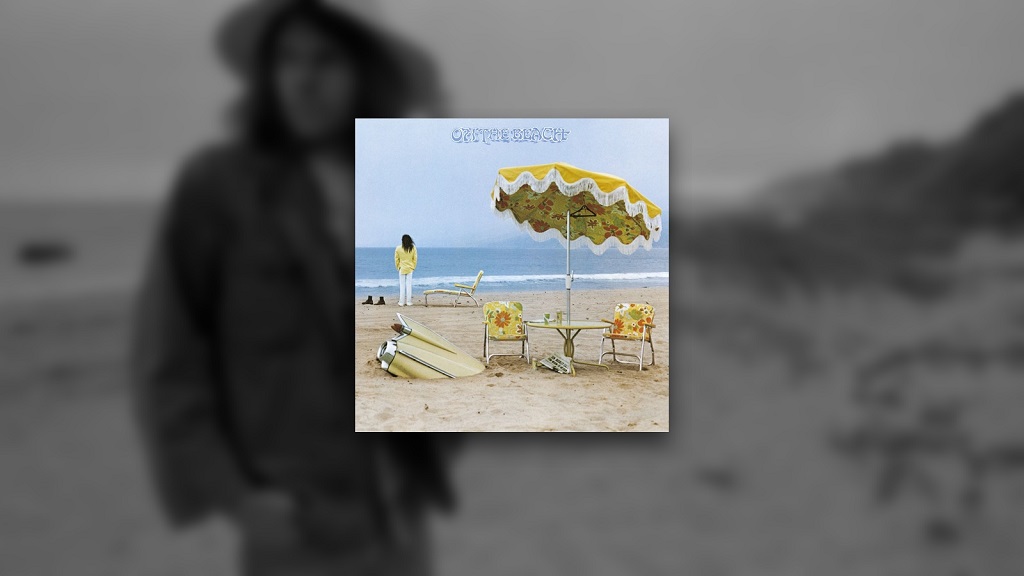 Neil Young’s On the Beach album cover displayed over a blurred photograph of Young standing on a beach