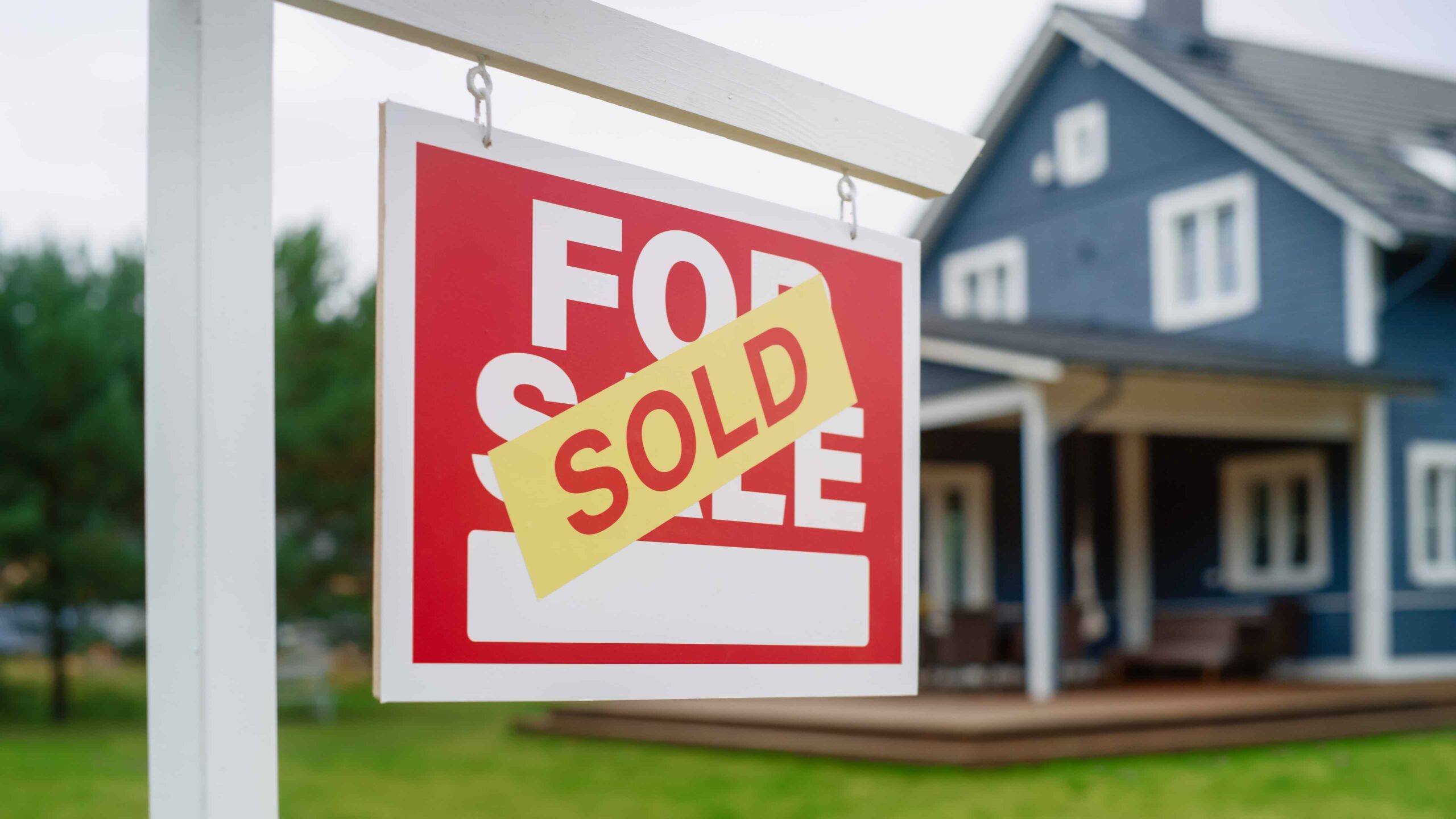 Sold sign displayed outside a residential house, representing completed home sales in the Arizona housing market.