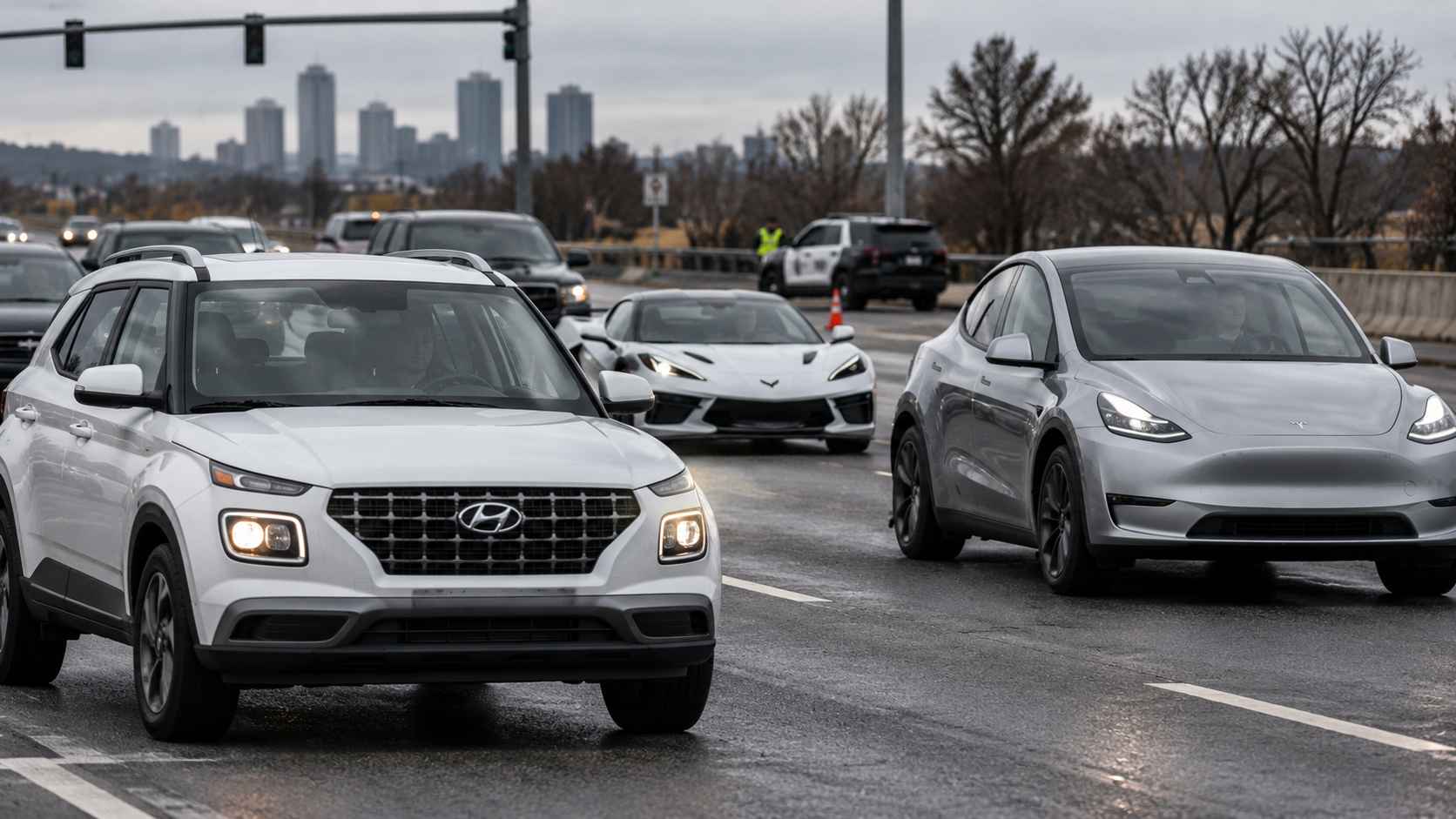 Hyundai Venue, Chevrolet Corvette and Tesla Model Y driving on a wet American city road.